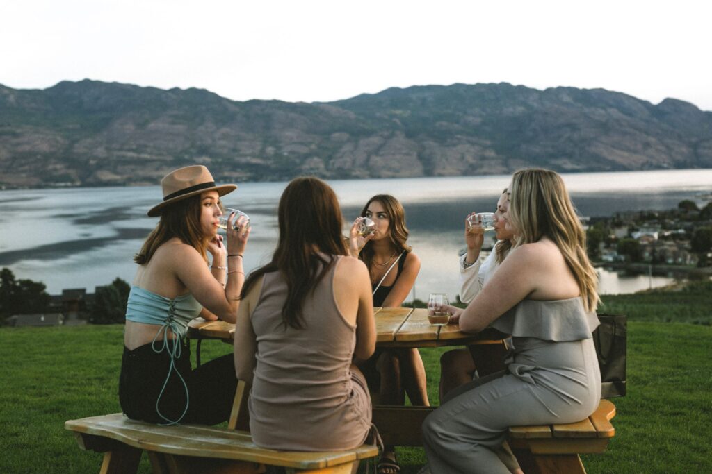 A group of people drinking wine in front of a mountain in British Columbia.