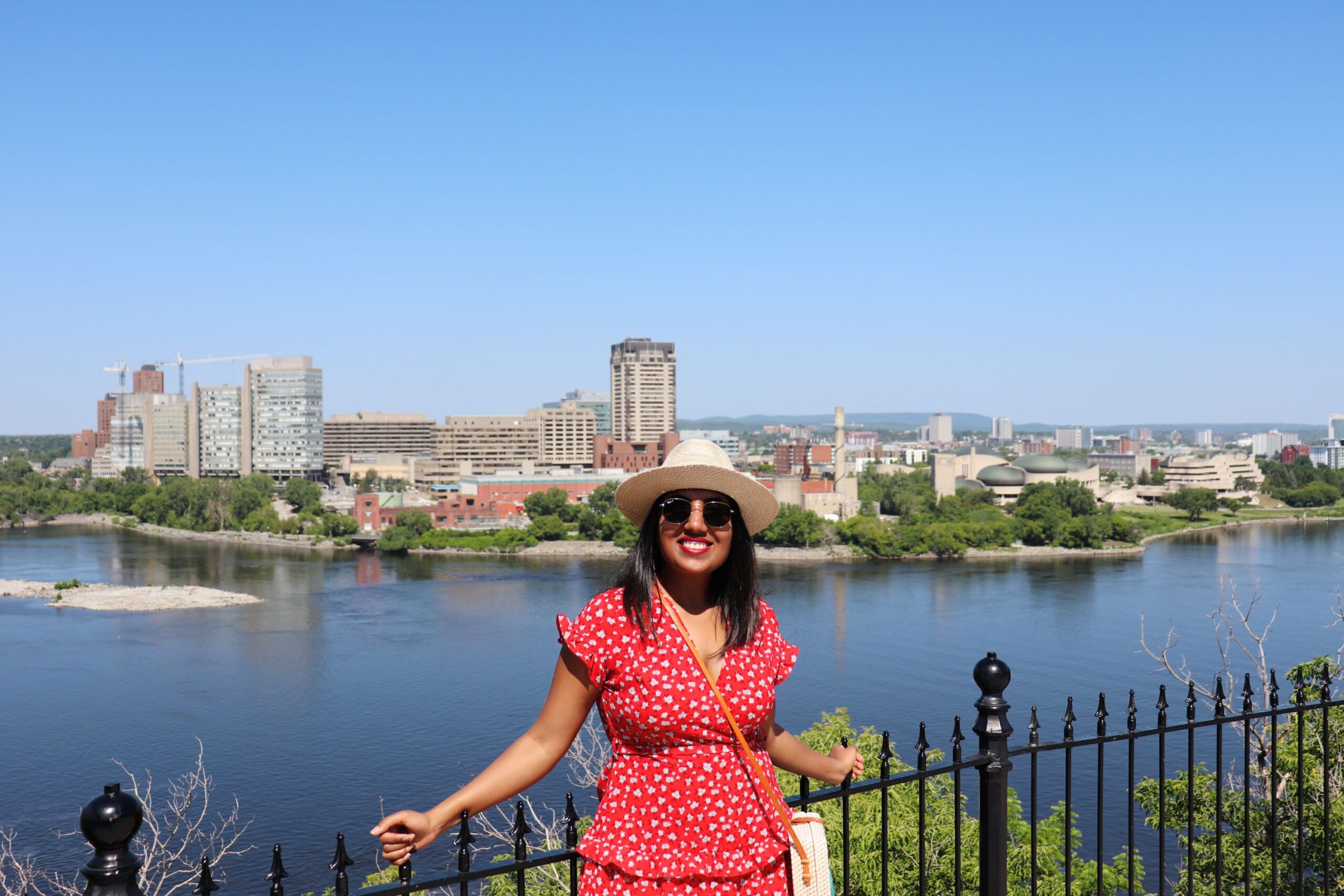 Photo of woman standing in front of the Rideau Canal from Parliament Hill in Ottawa.