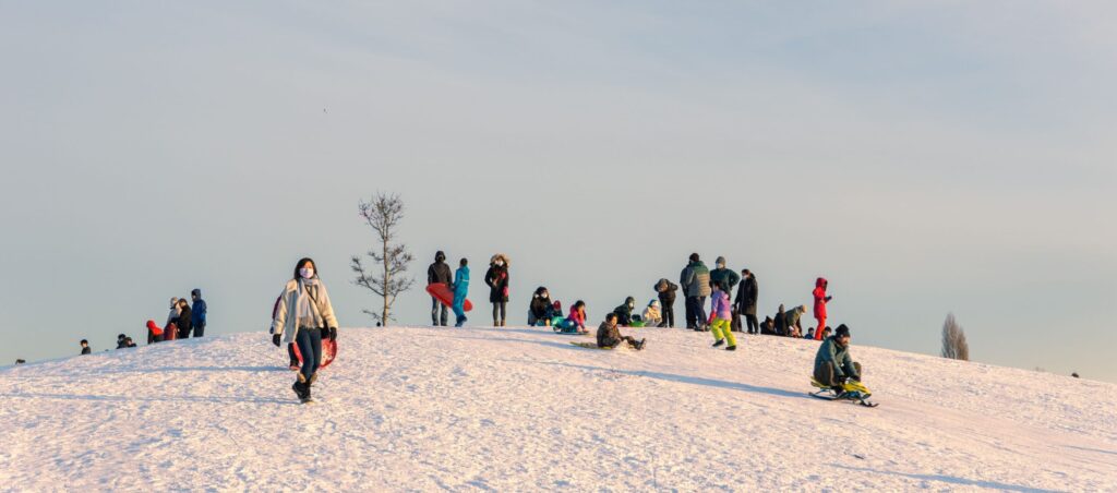 Photo of people sledding down a hill in the winter to stay active and overcome the winter blues.