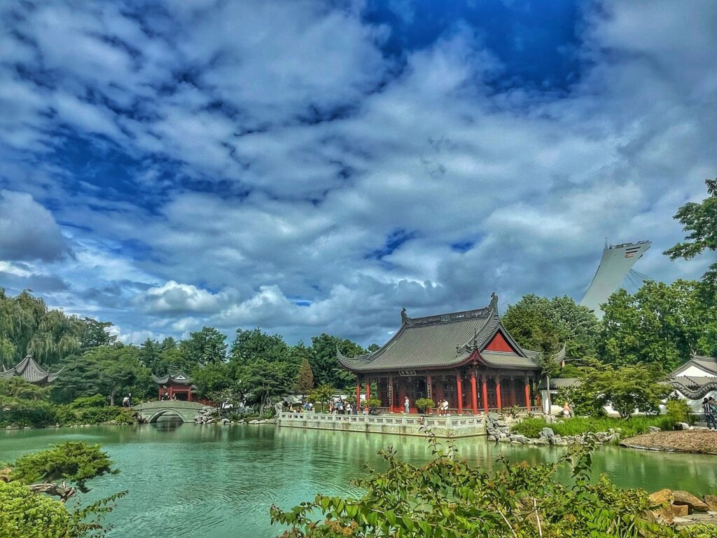 Photo of the Botanical gardens in Montreal with a red and black building in front of a body of water.