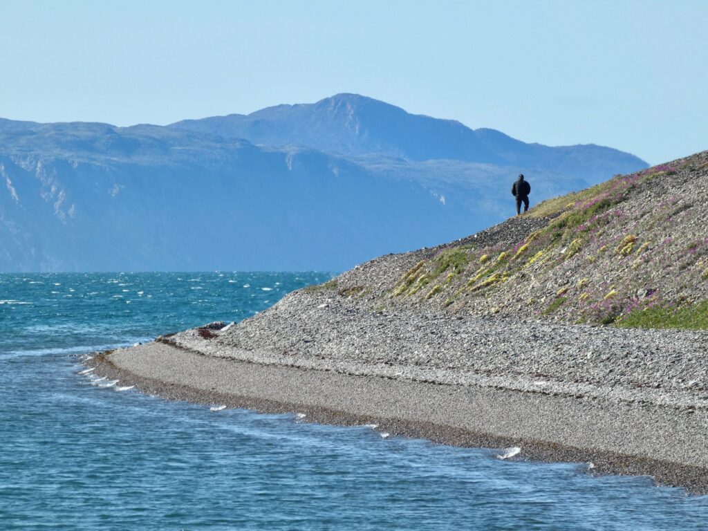 Person standing on a coastline near Pond Inlet, Nunavut
