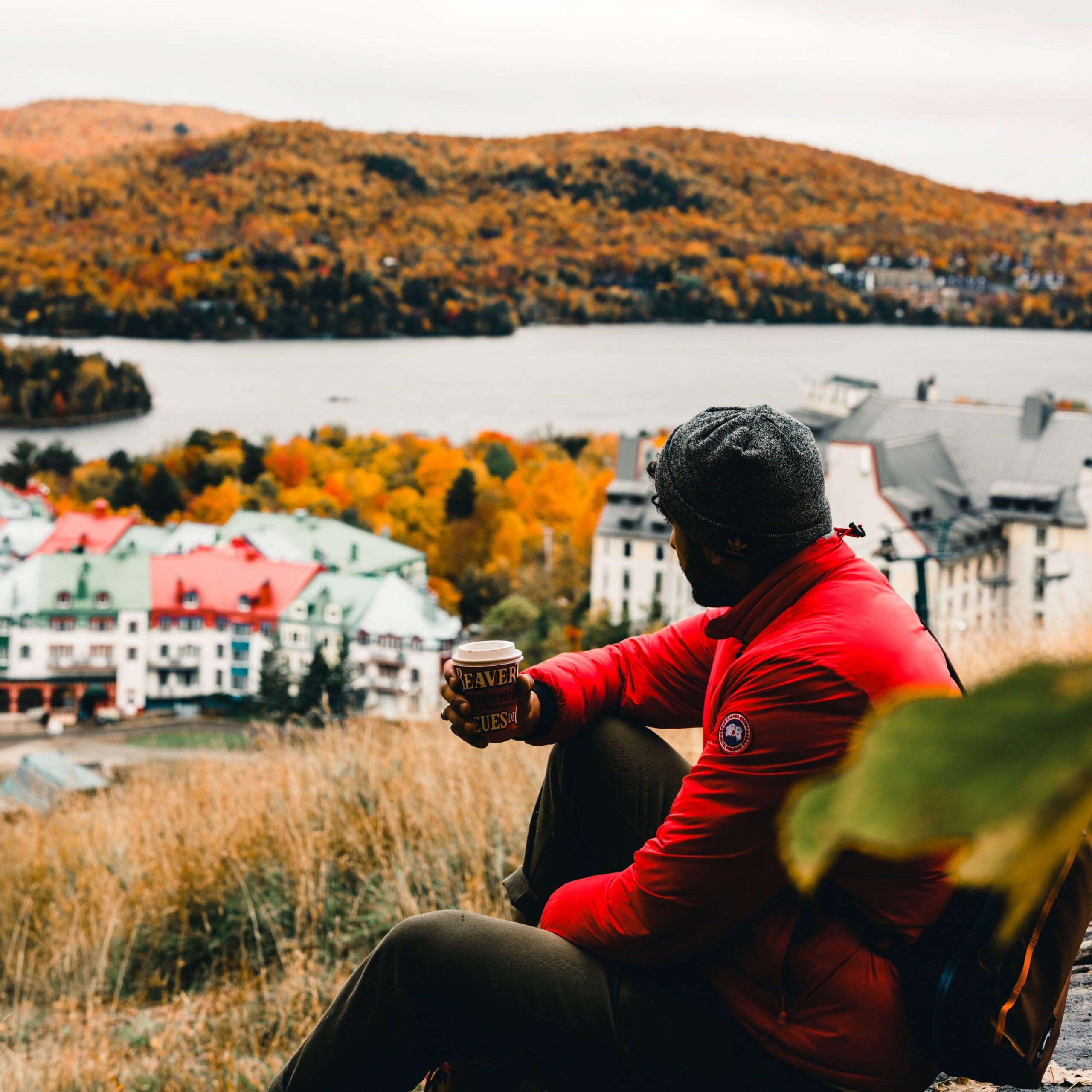 Photo of person drinking coffee while looking at the fall colours around Mont Tremblant.