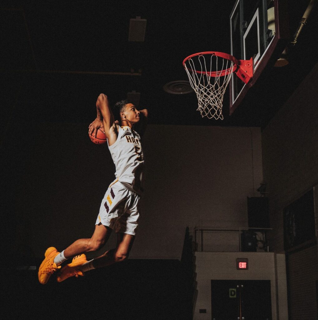 A young basketball player dunking in a youth game.