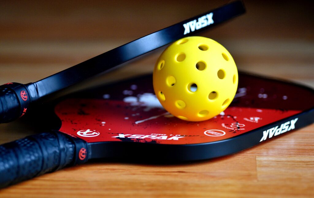 Pickleball paddles and yellow ball.