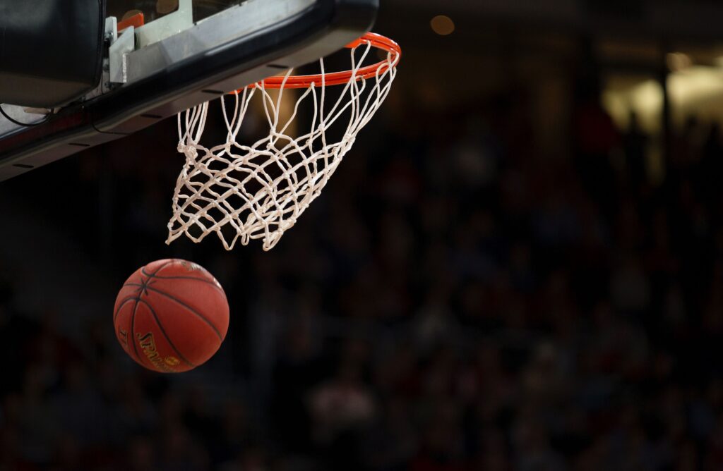 A basketball going through a hoop in an NBA game.