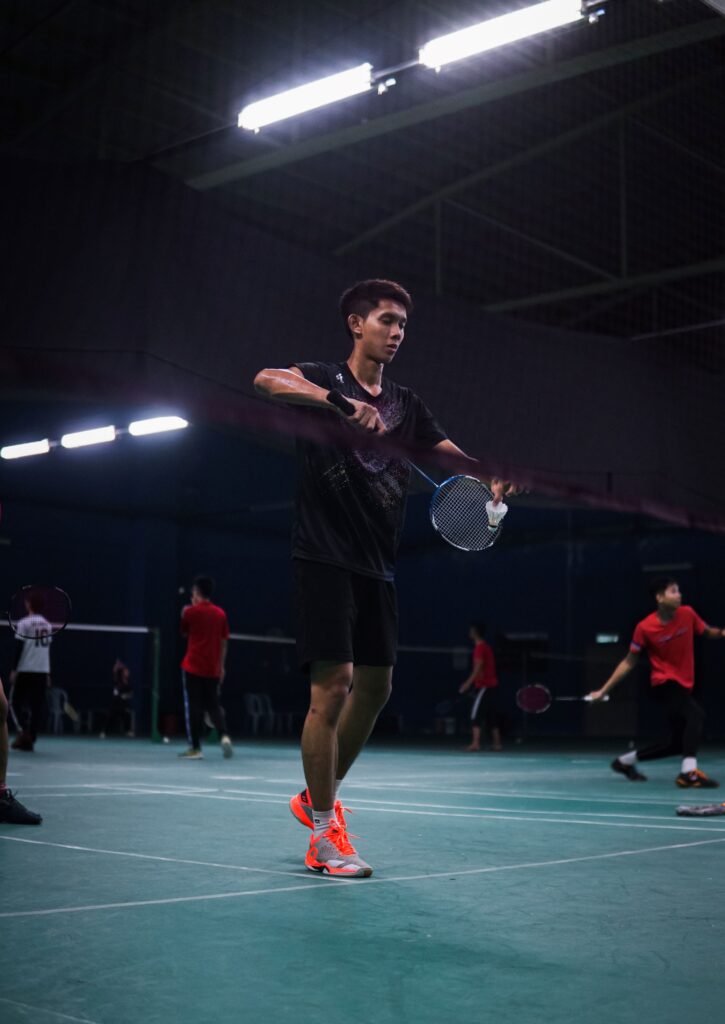 Person playing badminton in a tournament.