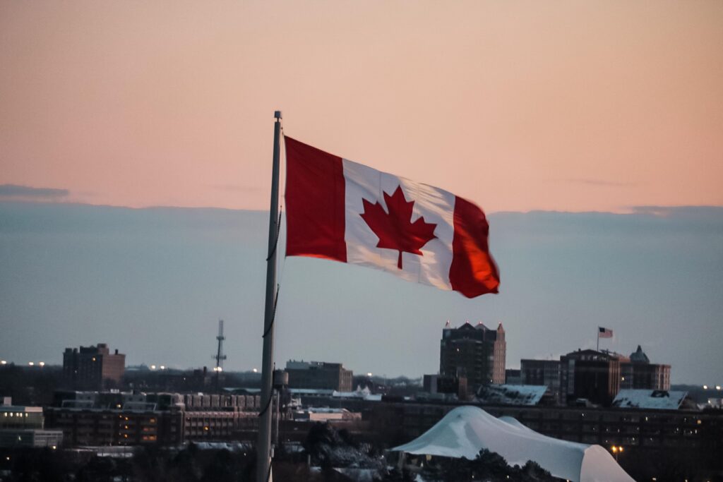 Canadian flag waving over a city skyline.