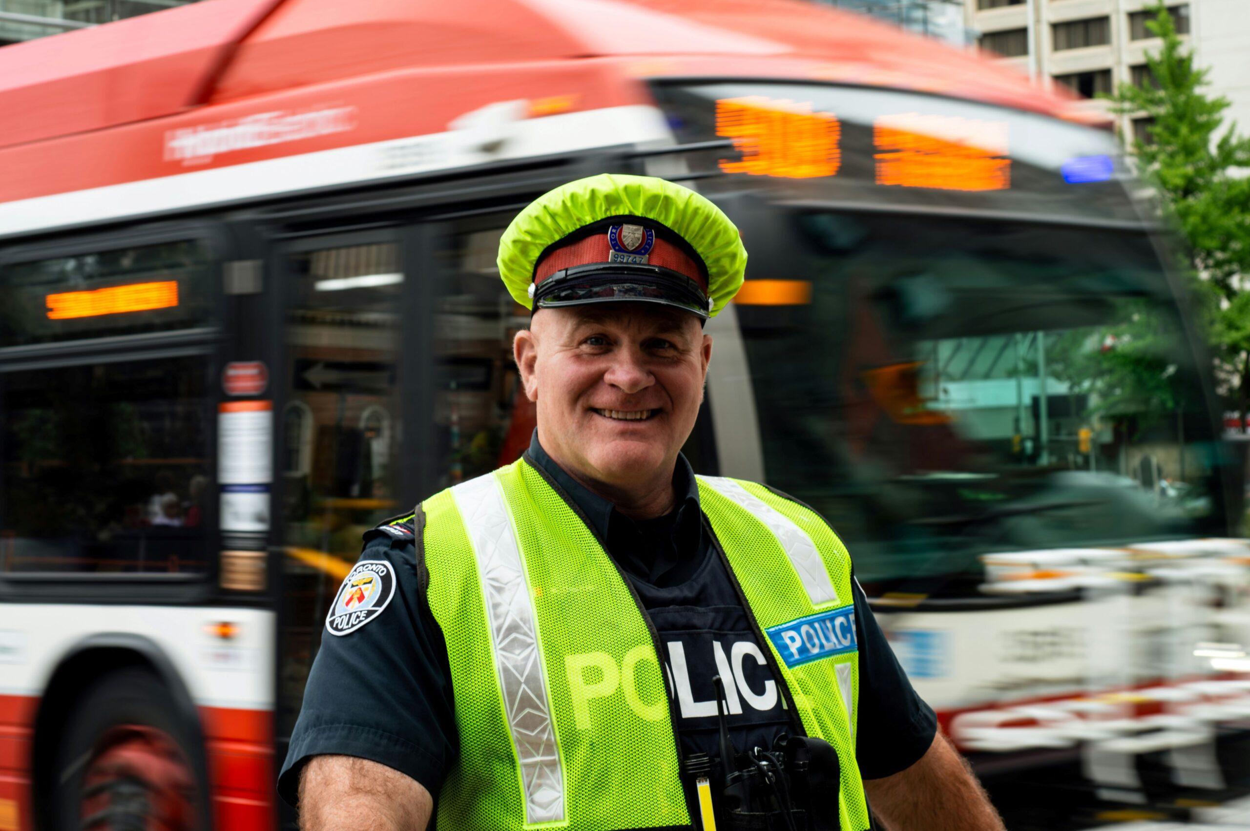 A photo of a police officer in front of a TTC vehicle.