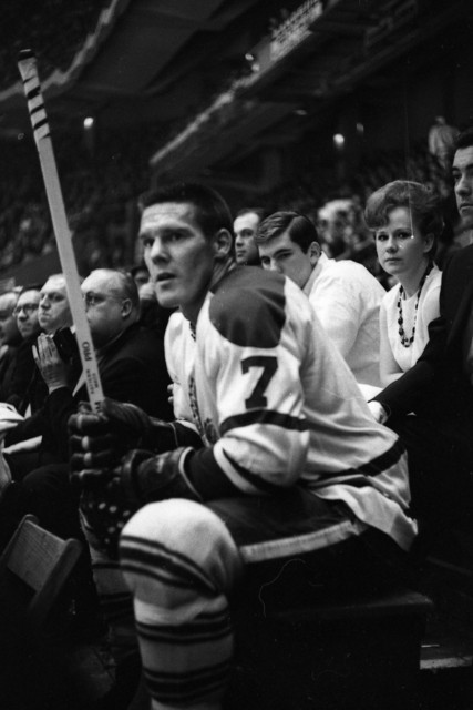 Photo of Tim Horton in a hickey uniform sitting on a bench.