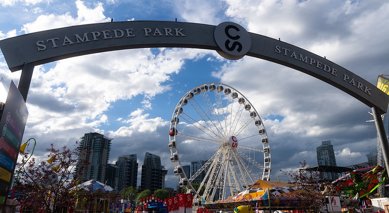 A photo of the Calgary Stampede Park with a ferris wheel and other rides.