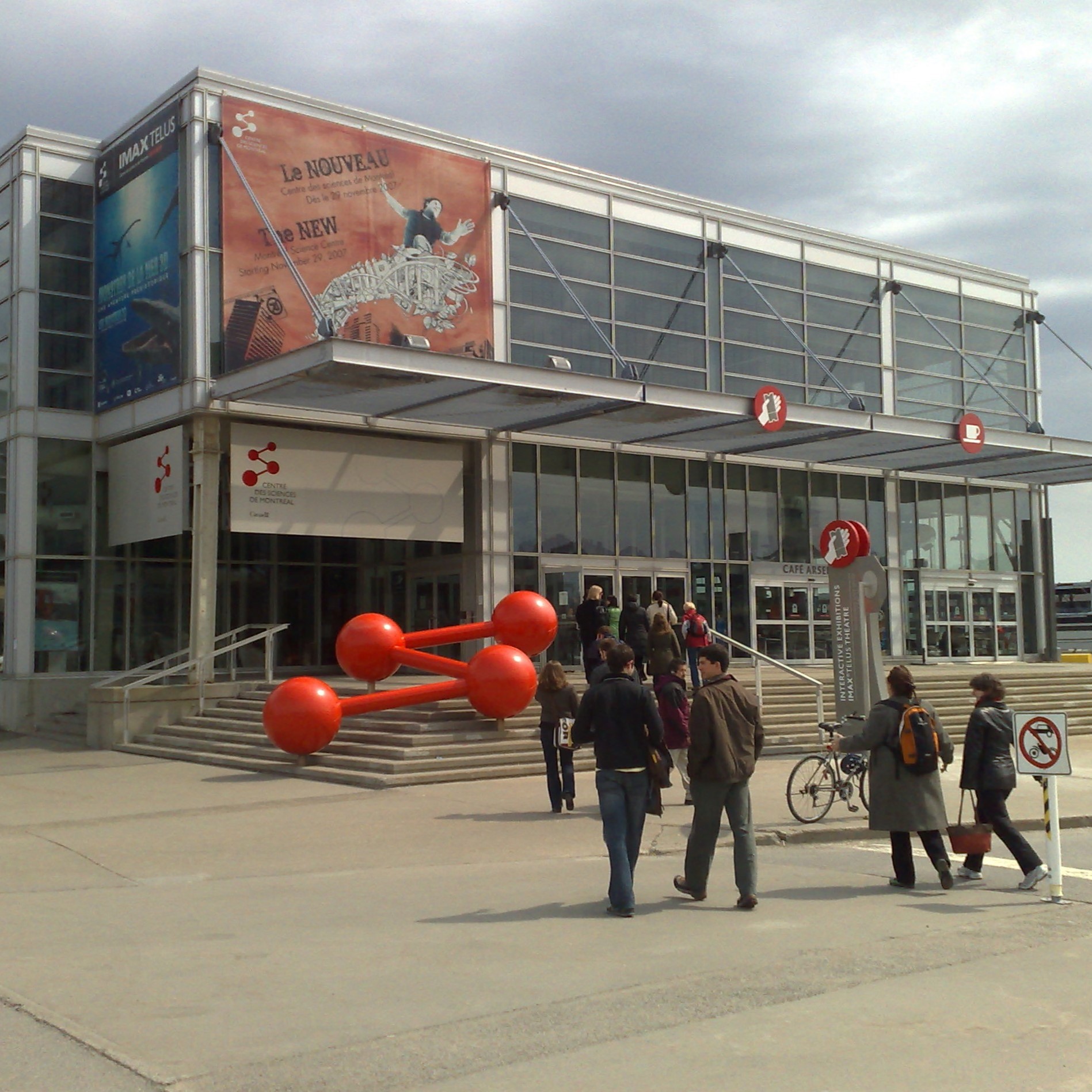 Exterior of the Montreal Science Centre with families walking towards the entrance.