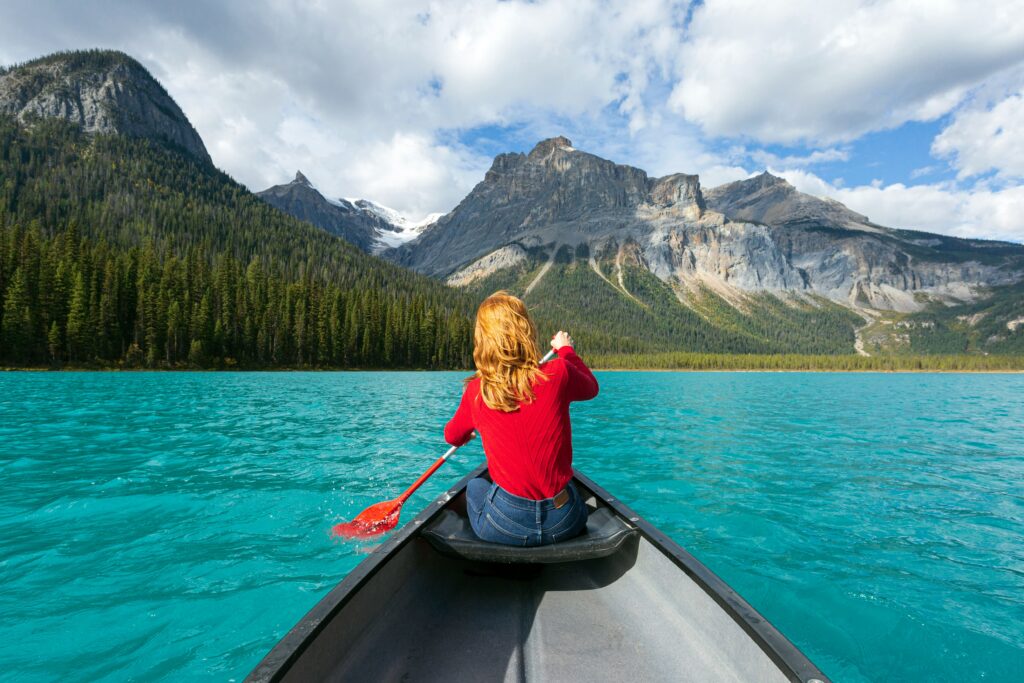 Women in red long sleeve shirt riding on a boat on the lake during daytime. 
