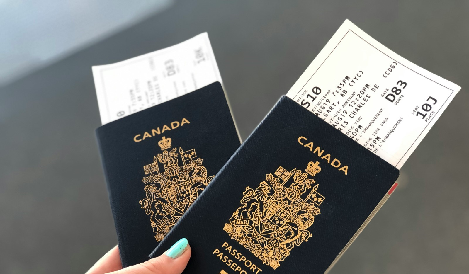 A hand holding Canadian passports.