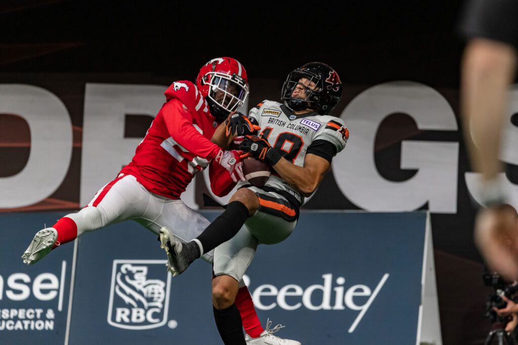 A Calgary Stempders player tackling a BC Lions football player