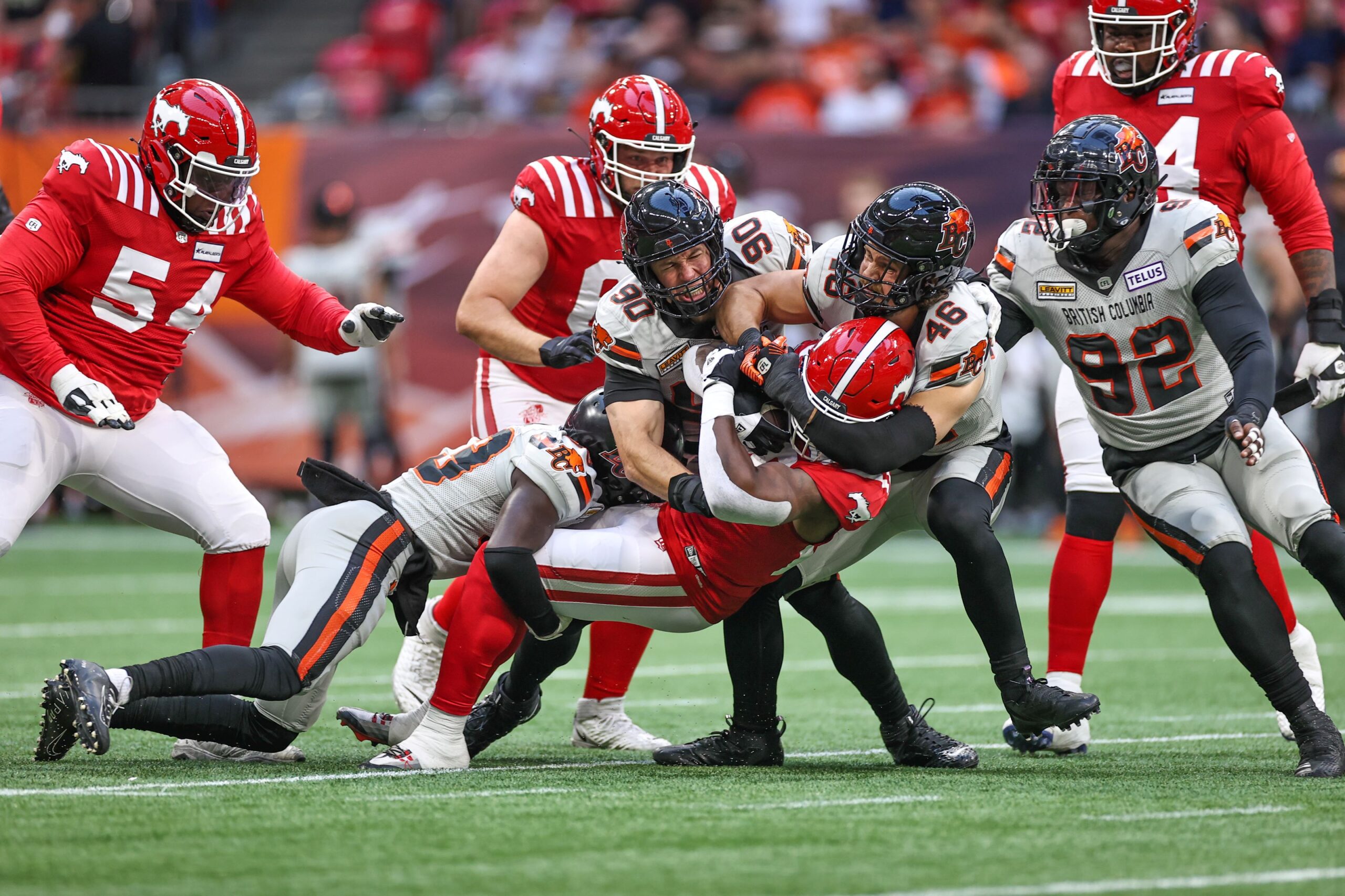 Calgary Stampeders tackling another football team during a game.