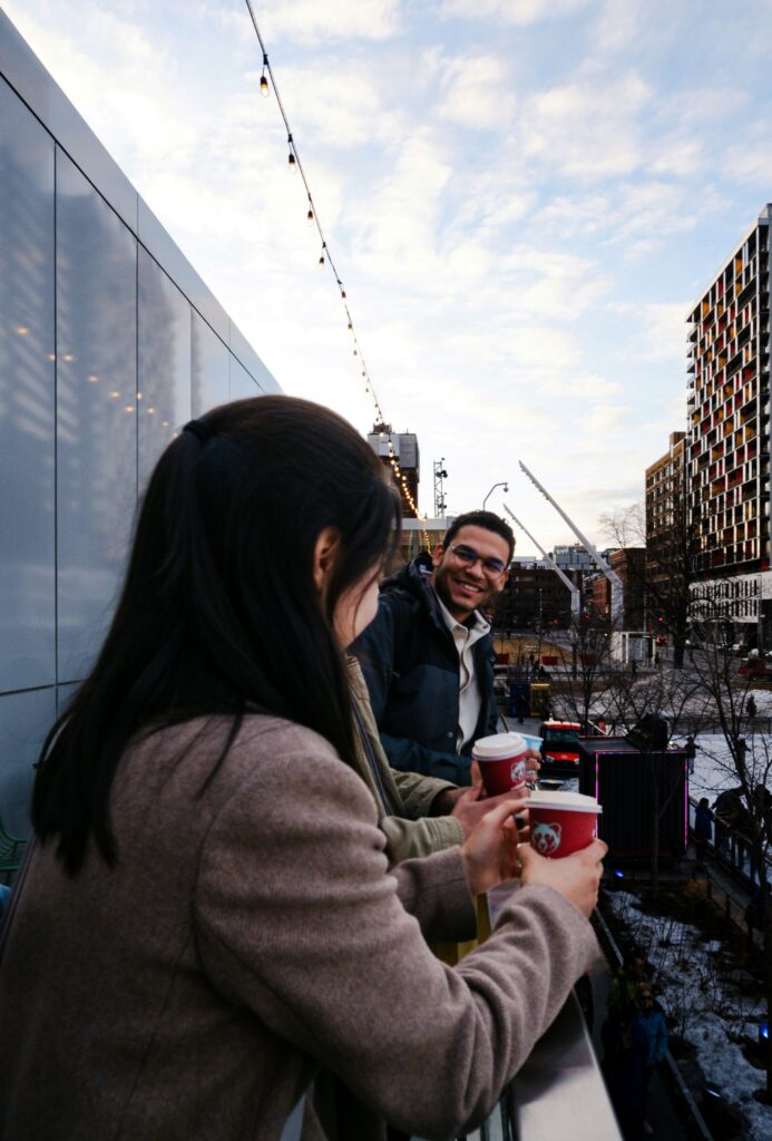 People smiling while holding coffee cups.