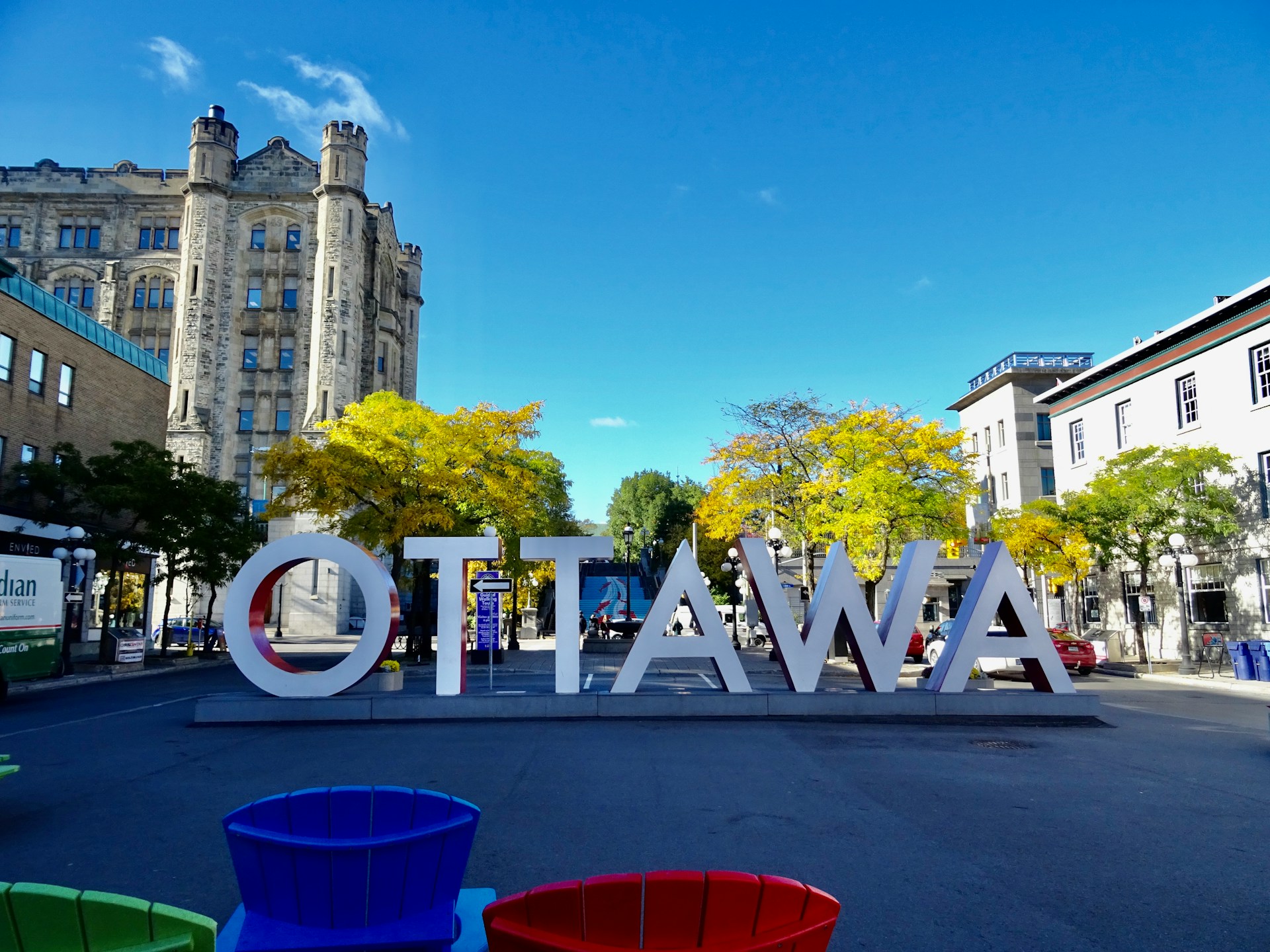 Ottawa sign on a road near green trees and buildings in the daytime