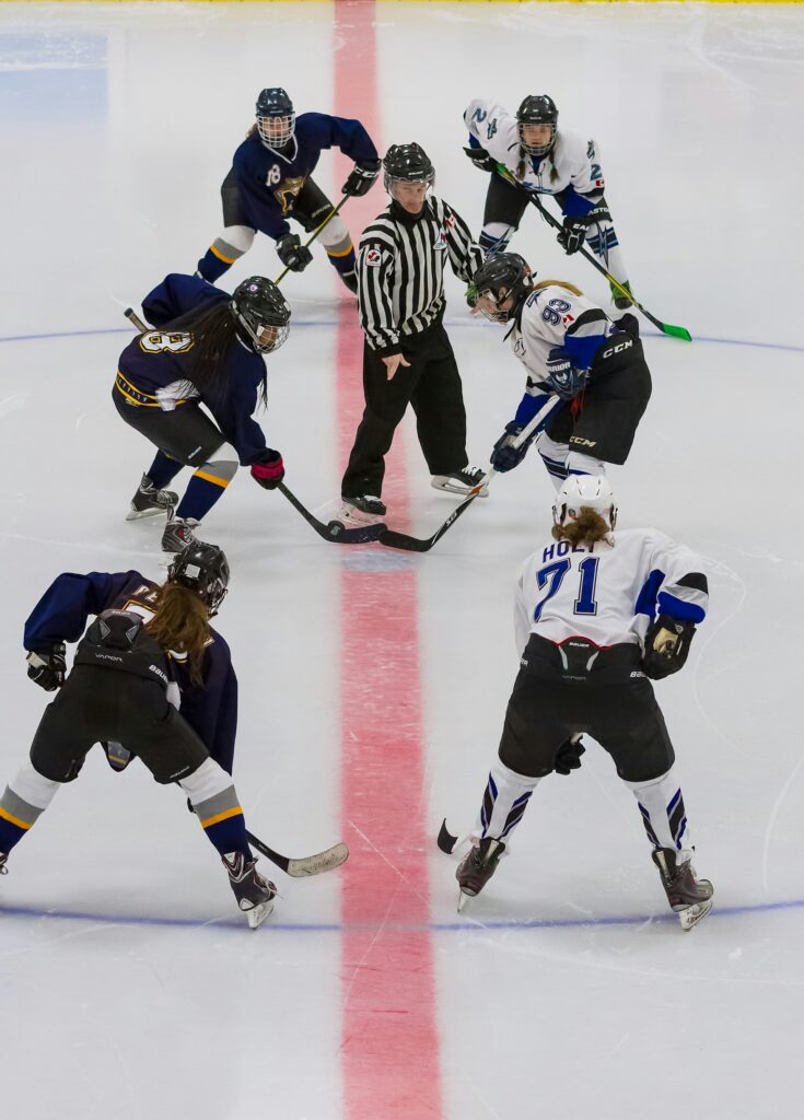 Women ice hockey players playing a game in an ice rink 
