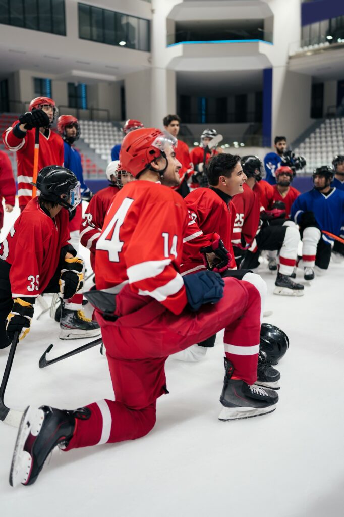 a group of young men sitting on the ice rink 