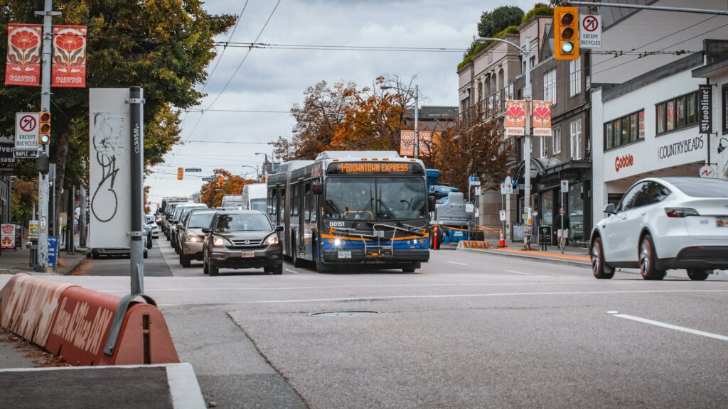 A city bus driving down a street next to tall buildings