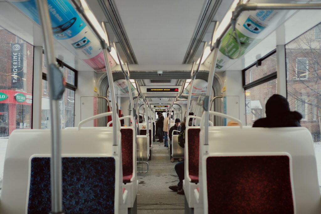 People sitting on a bus where the seats are white and blue in colour 