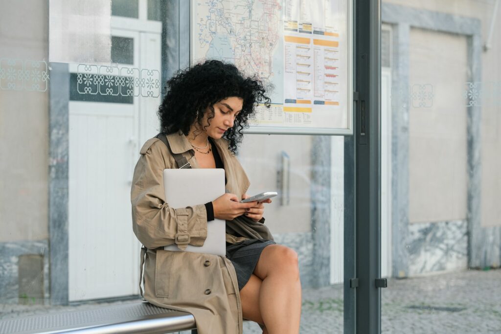 A woman sitting at a bus stop 