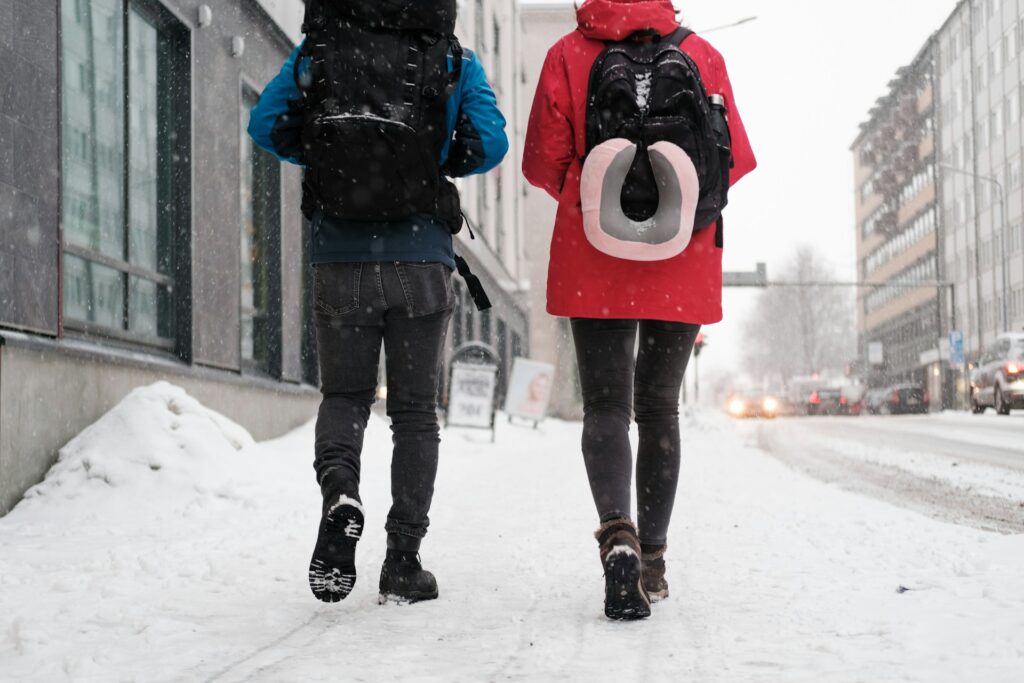 A couple of people walking down a snow-covered street