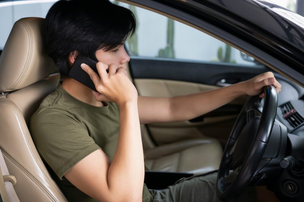 Driver calling roadside assistance for help while driving.
