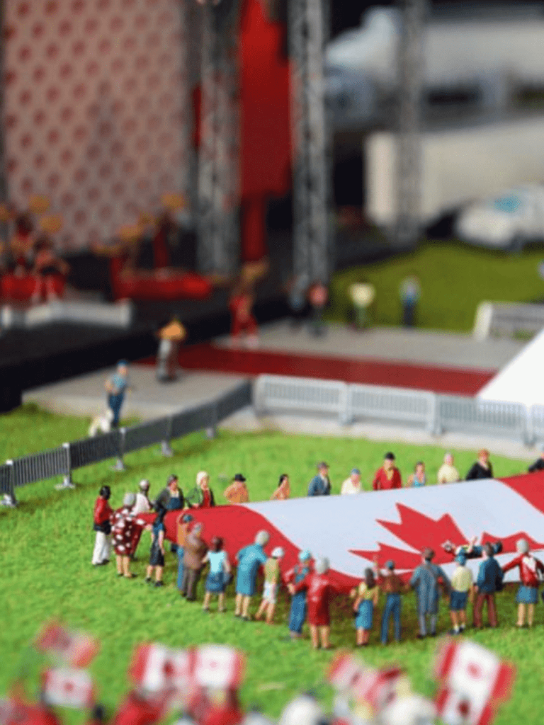 An image of characters holding a Canadian flag at Little Canada.