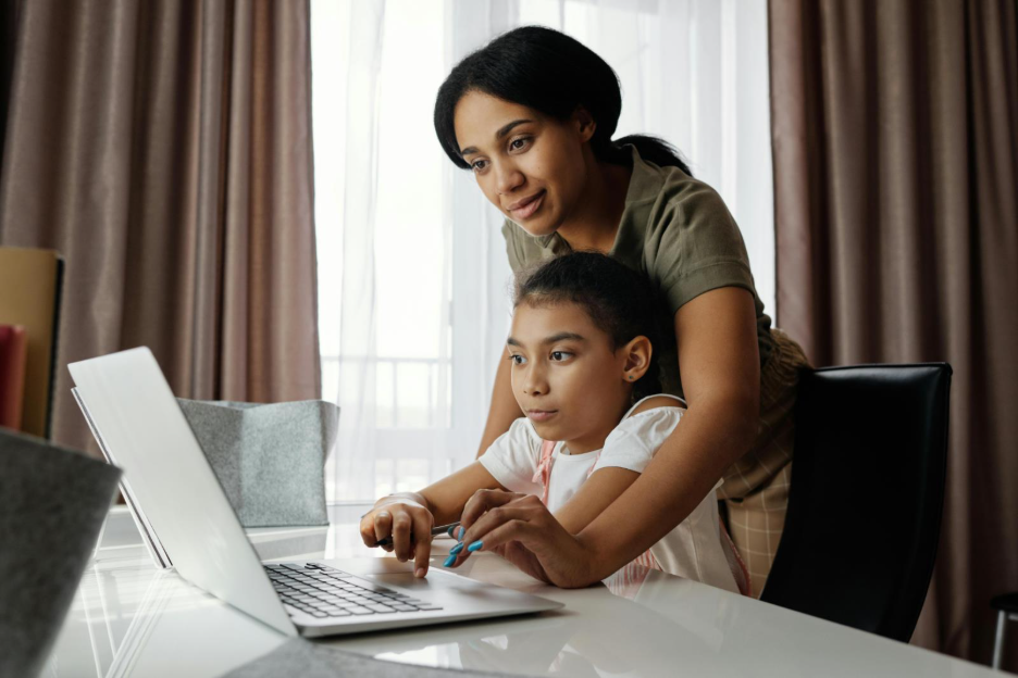 A family transferring money from Canada to India using a laptop.